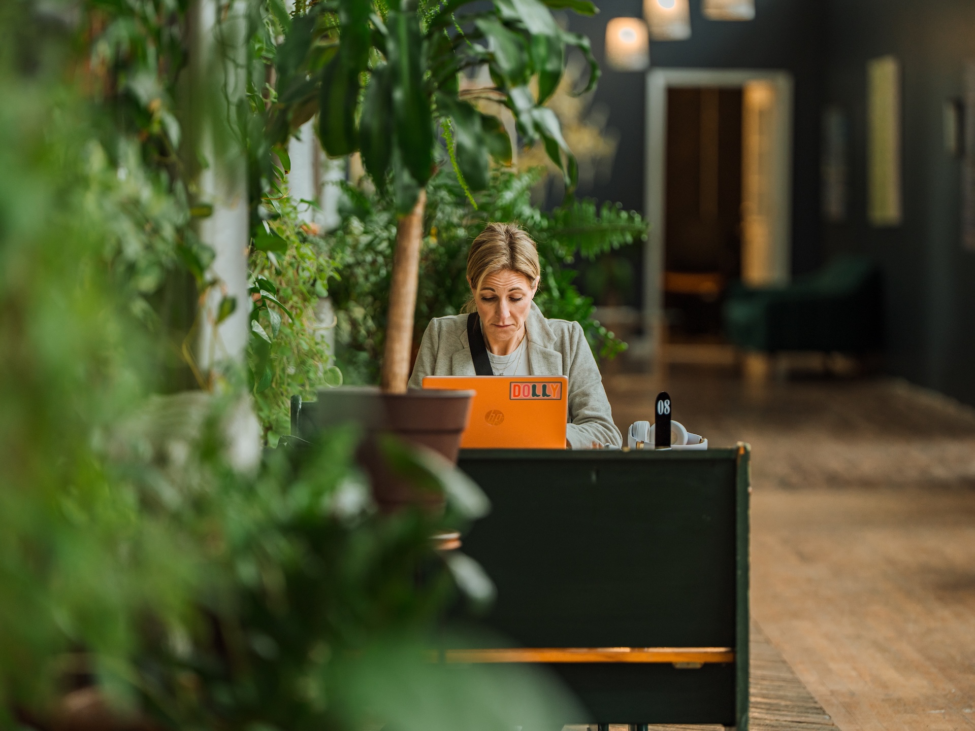 Guest working on laptop surrounded by plants at Earth Coffeehouse